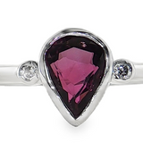 Lady's 14 Karat White Gold Ring featuring a Bezel-Set Pear-Shape Ruby and Diamond Accents